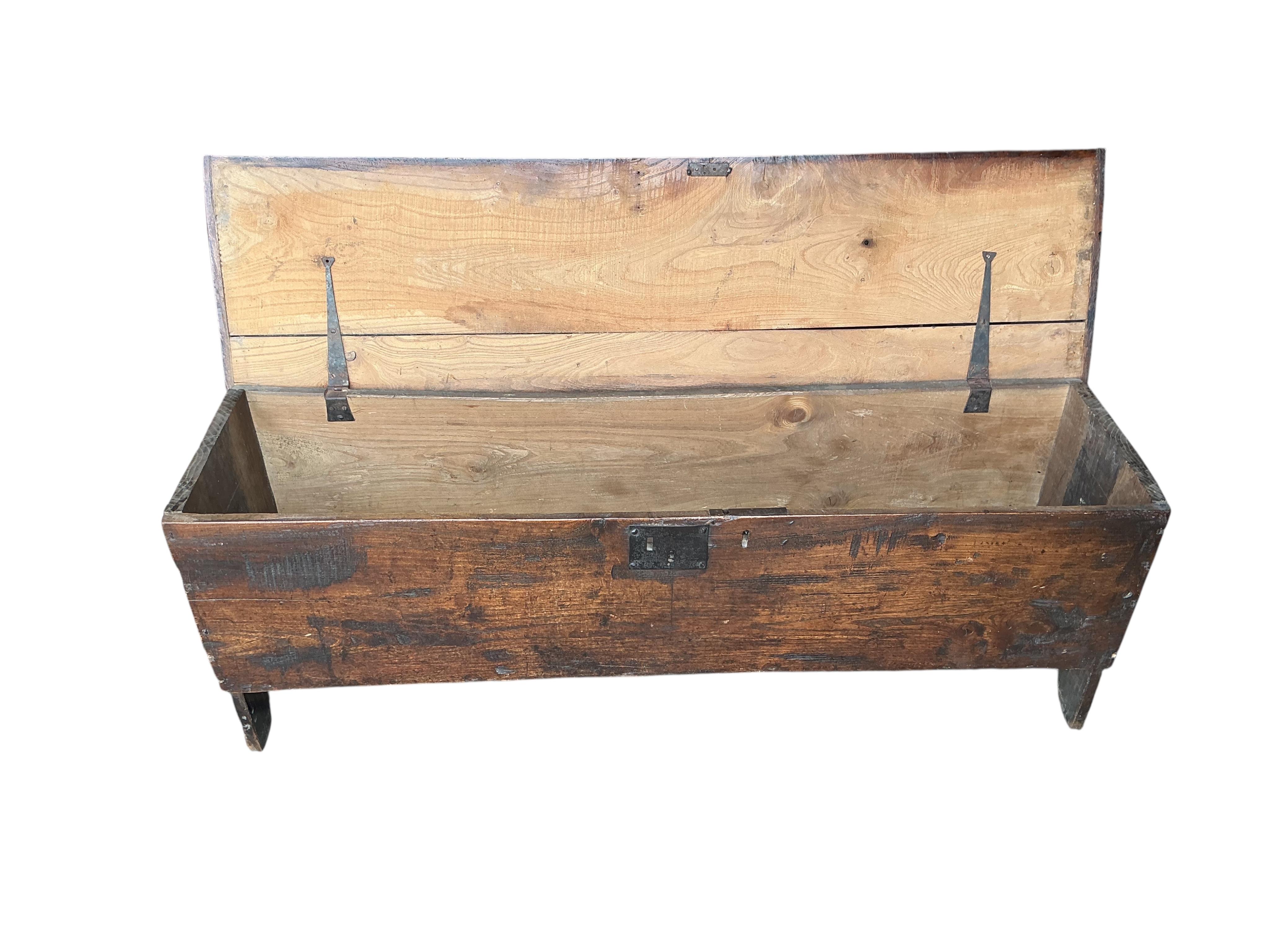 An early 18th century elm six plank coffer, width 136cm, depth 35cm, height 49cm